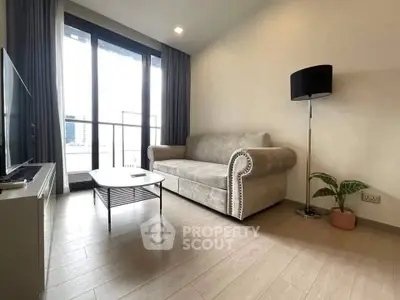 Modern living room with elegant sofa, floor lamp, and large window offering natural light and city views.
