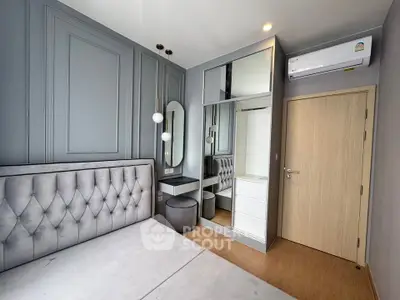 Modern bedroom with elegant design, featuring tufted headboard, mirrored wardrobe, and stylish lighting.