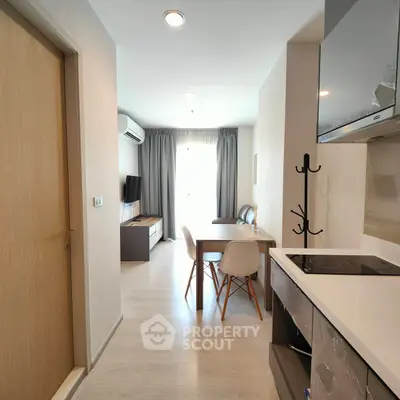 Modern open-plan living room with dining area and kitchen in a stylish apartment.