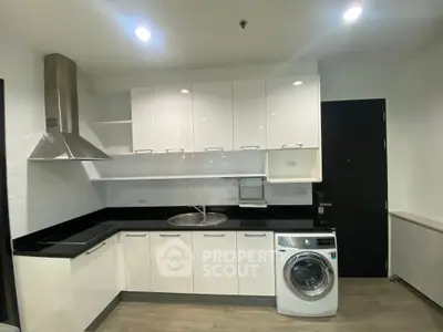 Modern kitchen with sleek white cabinets and built-in washing machine