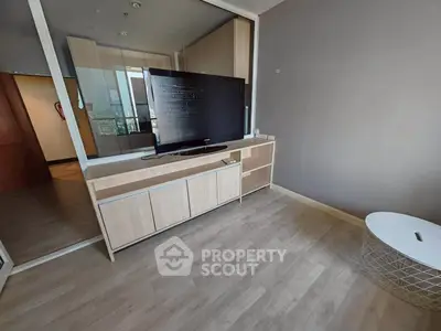 Modern living room with sleek TV setup and stylish wooden flooring.