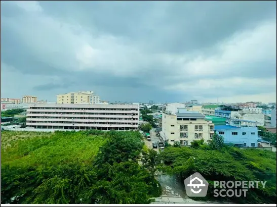 Stunning cityscape view with lush greenery and modern buildings under a dramatic sky.