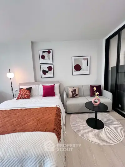 Modern bedroom with stylish decor and cozy seating area in a contemporary apartment.