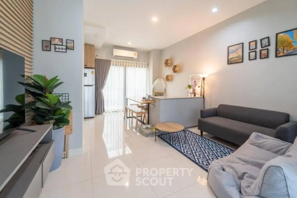 Modern living room with stylish decor and open layout, featuring a cozy sofa and dining area.