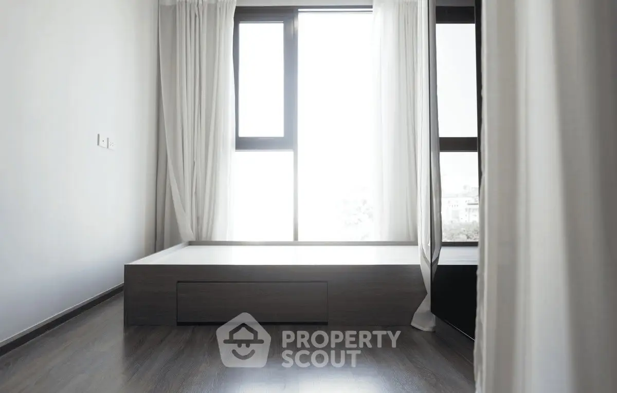 Minimalist bedroom with large windows and sleek wooden flooring