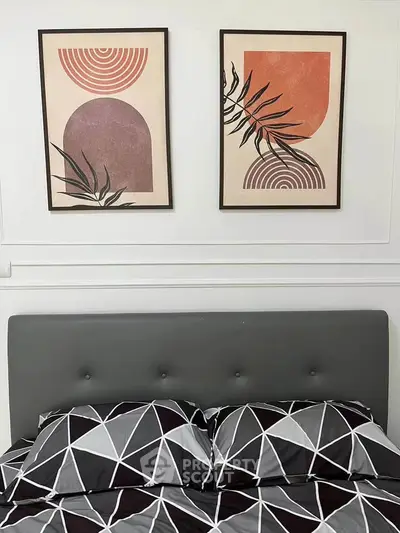 Stylish bedroom with modern geometric bedding and abstract wall art