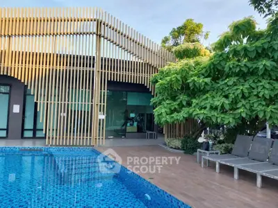 Modern poolside area with stylish architecture and lush greenery