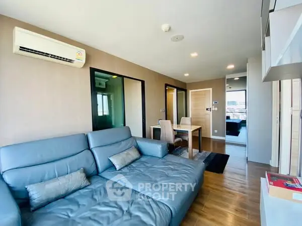 Modern living room with blue sofa and dining area in a stylish apartment