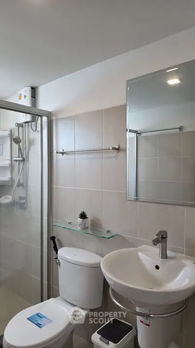 Modern bathroom with glass shower and sleek fixtures in a contemporary apartment.