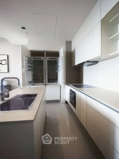 Sleek modern kitchen with open fridge and minimalist design