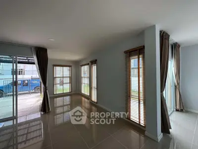 Spacious modern living room with large windows and sleek tile flooring