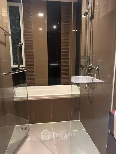 Modern bathroom with sleek brown tiles and glass shower enclosure