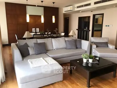 Spacious living room with modern decor and cozy seating in a stylish apartment.