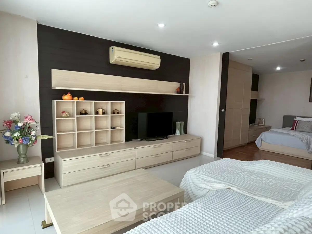 Spacious modern living room with stylish furniture and cozy bedroom area