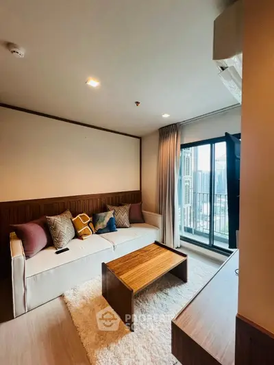 Modern living room with cozy sofa and city view balcony in high-rise apartment.