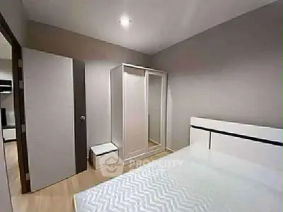 Modern bedroom with sleek design and mirrored wardrobe in a stylish apartment.