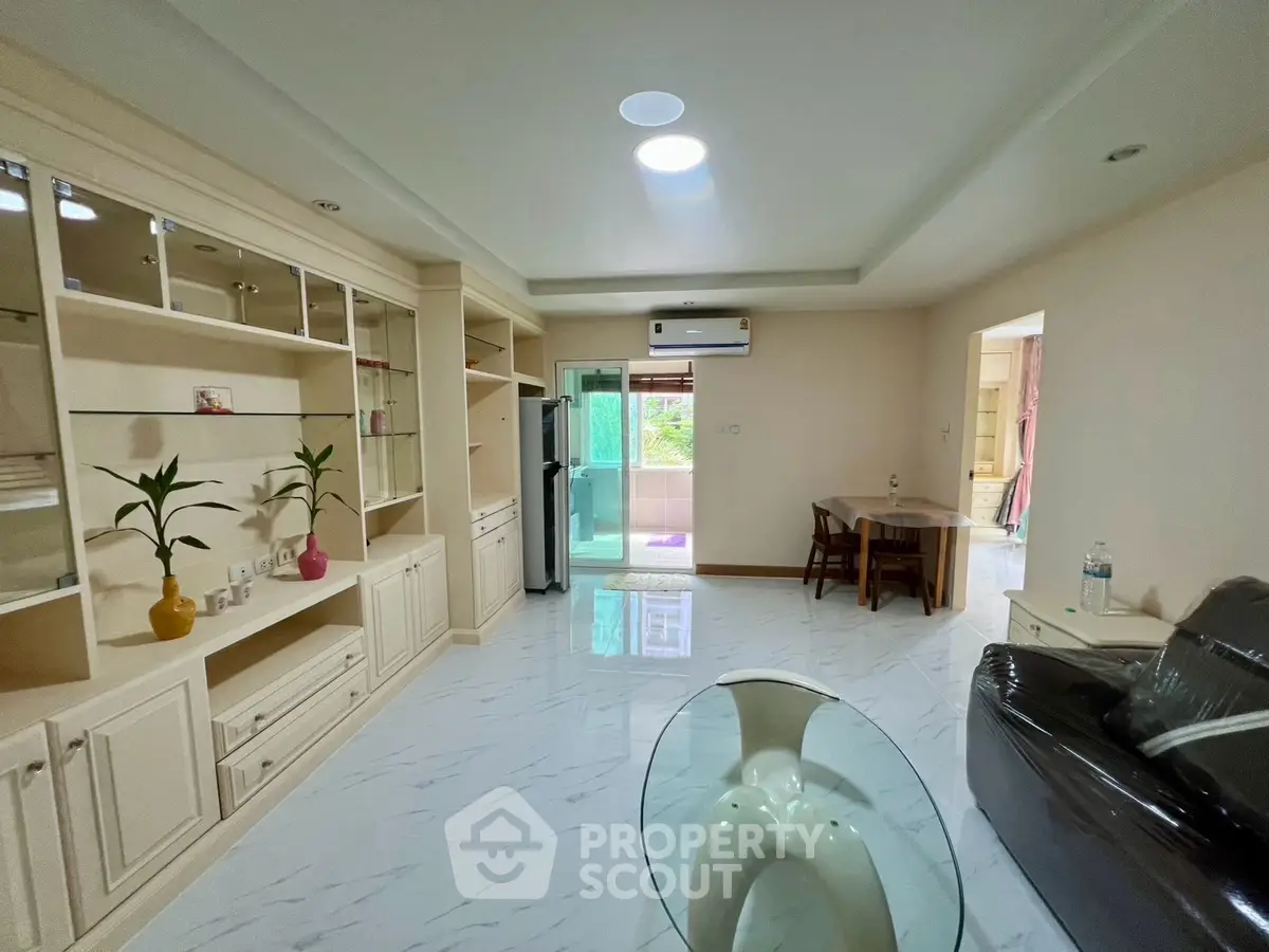 Spacious living room with modern furnishings and balcony access in a stylish apartment.