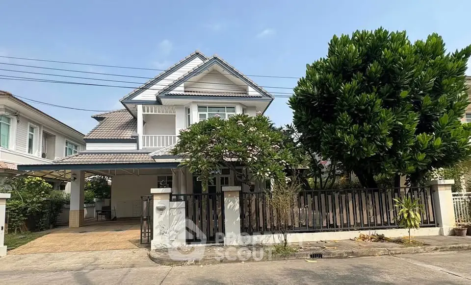 Charming two-story house with lush garden and spacious driveway in a serene neighborhood.