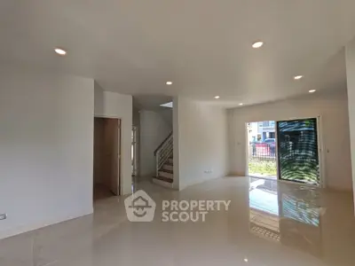 Spacious modern living room with glossy floors and large windows in a contemporary home.