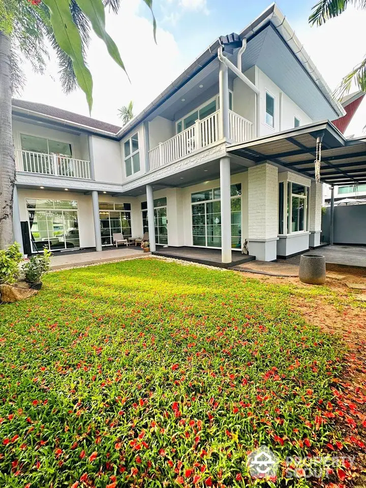 Stunning two-story home with lush garden and spacious balcony, perfect for family living.