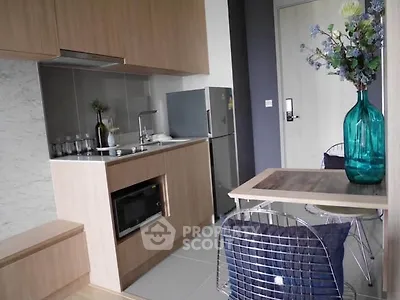 Modern compact kitchen with sleek cabinetry and dining area in stylish apartment