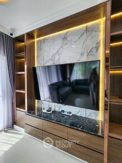 Luxurious living room with modern TV setup and elegant marble accents