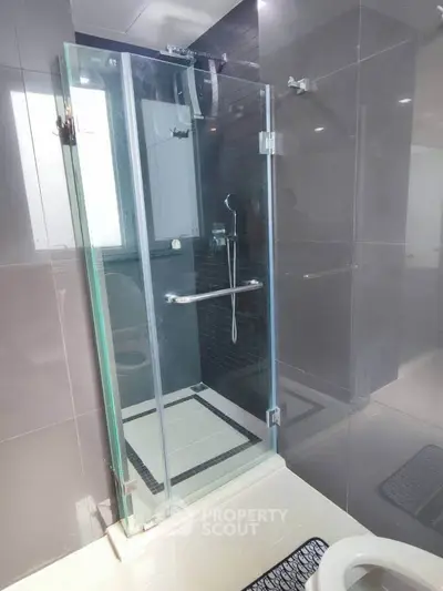 Modern bathroom with sleek glass shower enclosure and elegant tile design.