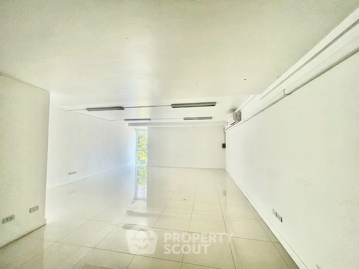 Spacious white interior with glossy tiled floors and modern lighting, ideal for versatile use.