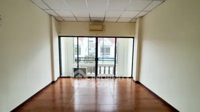 Spacious empty room with large windows and balcony view, perfect for customization.
