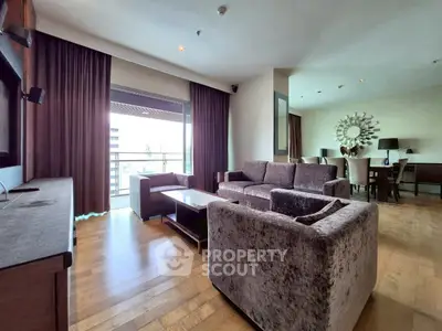 Spacious living room with modern furniture and large windows offering city views.