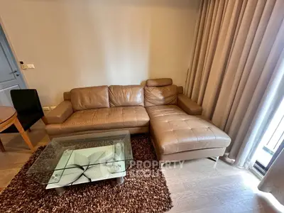 Stylish living room with modern leather sofa and glass coffee table, perfect for relaxation.