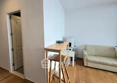 Modern living room with wooden flooring, cozy sofa, and minimalist decor