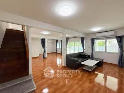 Spacious living room with polished wooden floors and modern furniture