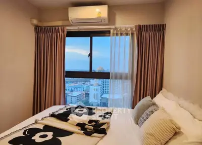 Cozy bedroom with city view, featuring plush bedding and air conditioning for ultimate comfort.