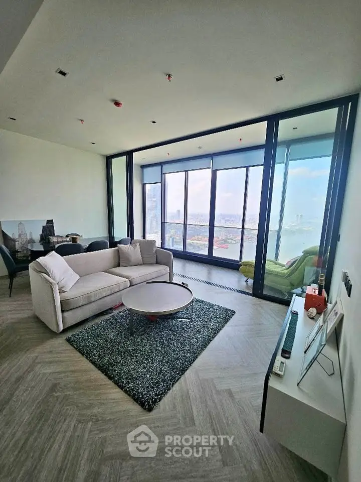 Luxurious living room with stunning city view and spacious balcony in modern high-rise apartment.