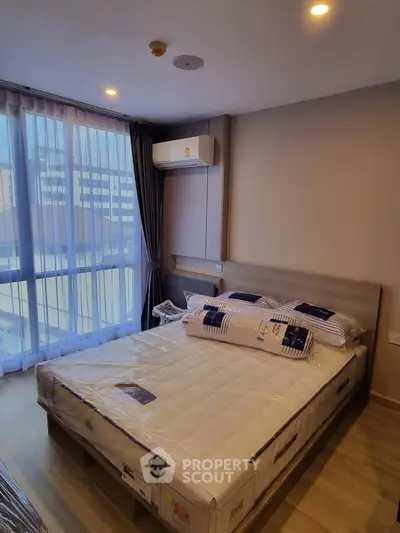 Modern bedroom with large window and natural light in urban apartment