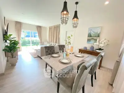 Elegant living room with dining area, modern decor, and large windows for natural light.