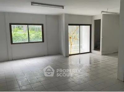 Spacious unfurnished room with large windows and tiled flooring, ideal for customization.