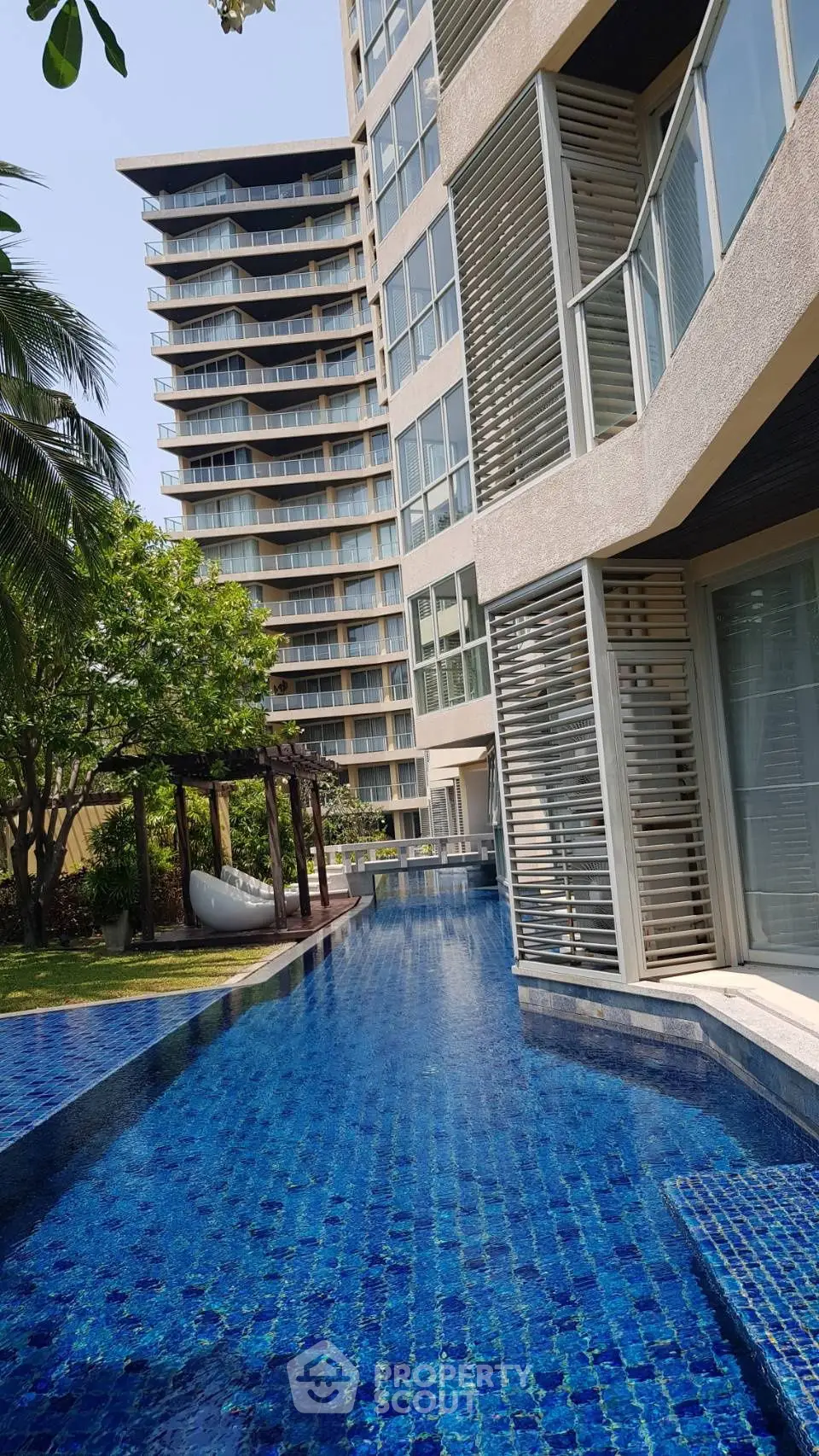 Luxurious high-rise building with stunning pool and lush garden view.