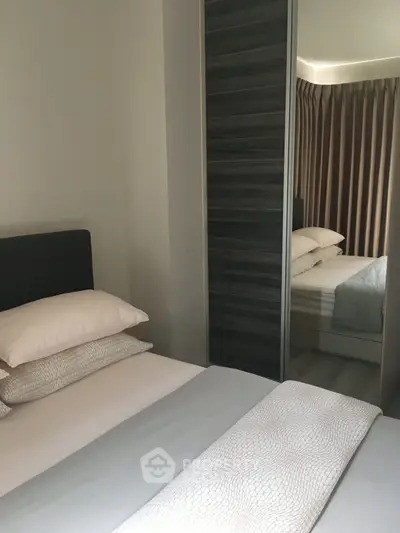 Modern bedroom with mirrored wardrobe and elegant bedding in a stylish apartment.