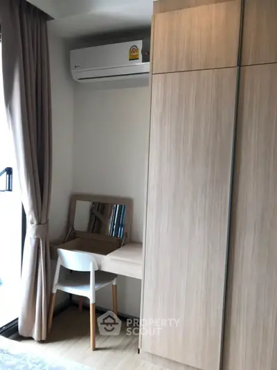 Cozy bedroom corner with built-in wardrobe and study desk near window.