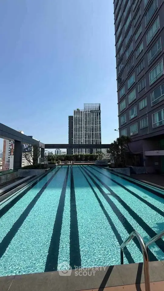 Luxurious high-rise building with stunning rooftop pool and city views.