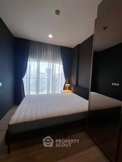 Modern bedroom with large window and stylish dark curtains, featuring a comfortable bed and sleek design.