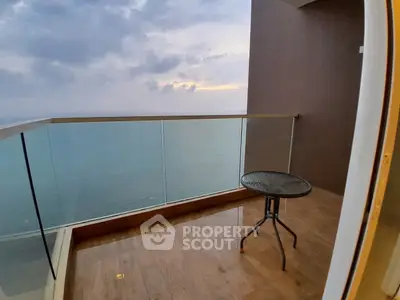 Stunning ocean view from a modern balcony with glass railing, perfect for relaxation.