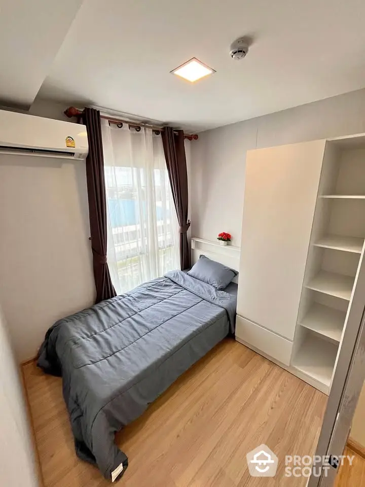 Cozy bedroom with modern furnishings and natural light in a stylish apartment.