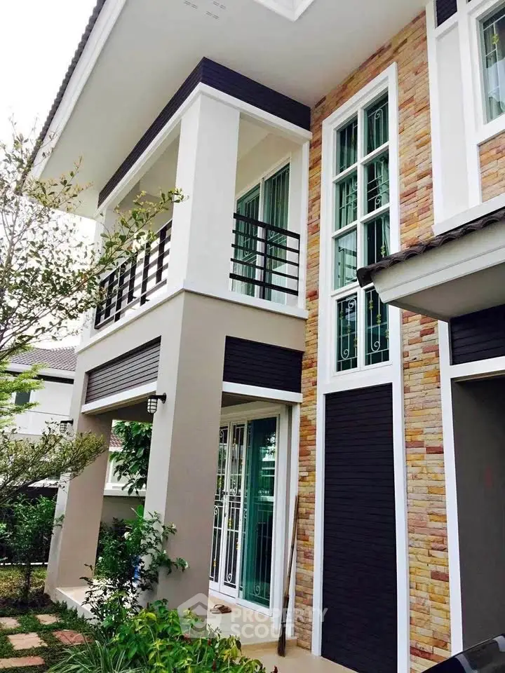 Modern two-story house with stylish stone facade and large windows