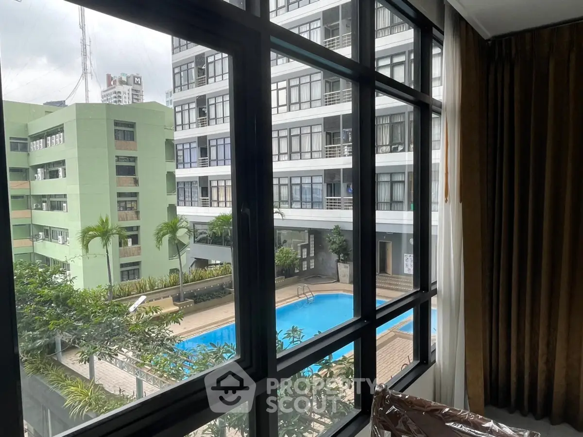 Modern apartment view with pool and lush greenery, perfect for urban living.