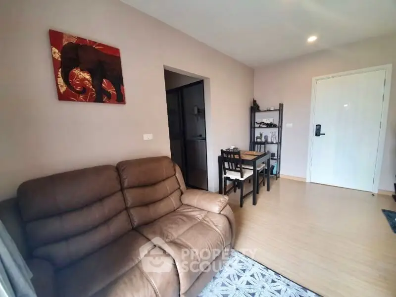 Spacious living room with modern furnishings, sleek hardwood flooring, and a warm neutral color palette, perfect for relaxation or entertaining guests.