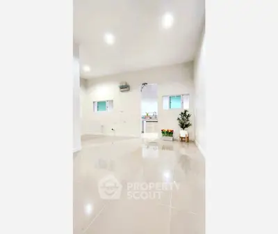 Spacious modern interior with glossy tiled floors and minimalist decor.
