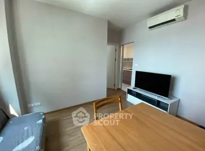 Modern living room with air conditioning and TV, featuring minimalist furniture and wooden flooring.